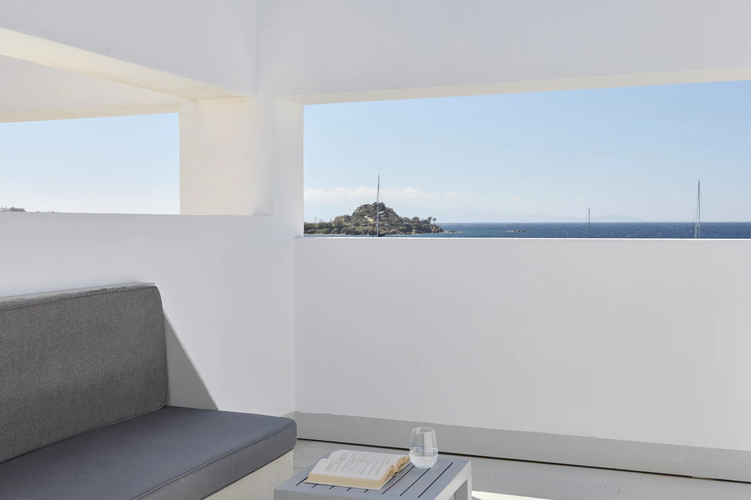 Balcony looking over Platis Gialos bay with sailboats on the horizon